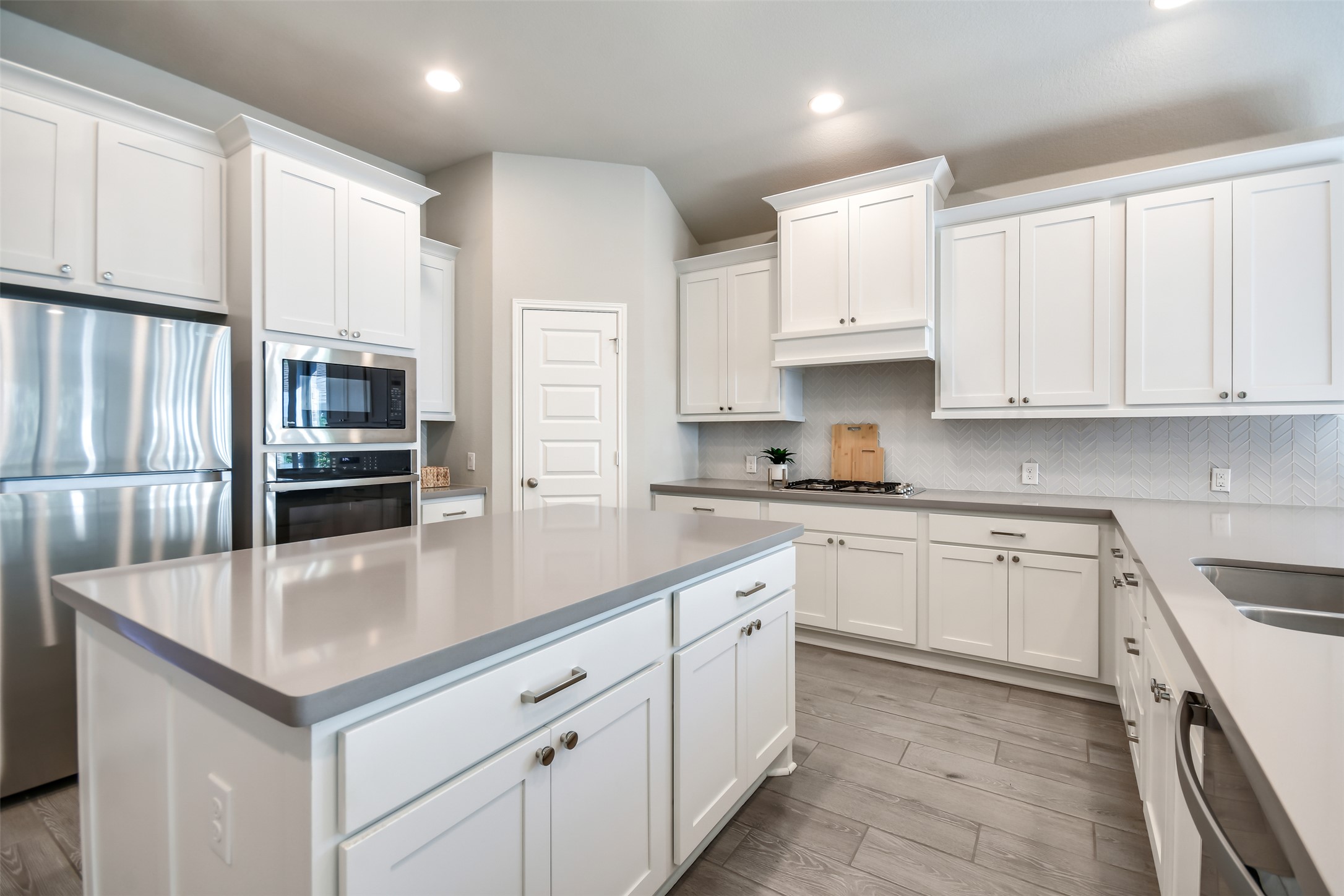 228 Pisa Lane Georgetown, TX 78628 - Photo 5 of 28 a kitchen with stainless steel appliances granite countertop a refrigerator a sink dishwasher a oven and white cabinets with wooden floor