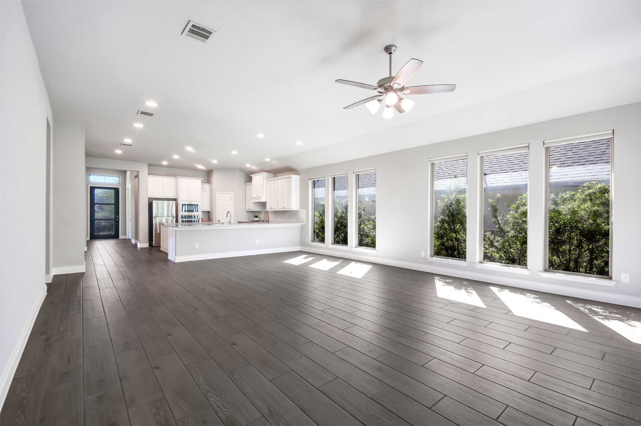 228 Pisa Lane Georgetown, TX 78628 - Photo 7 of 28 a view of an empty room with wooden floor and a kitchen
