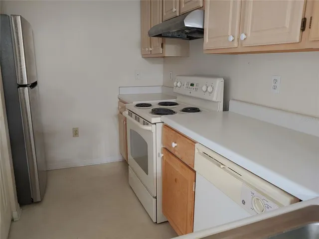 a kitchen with stainless steel appliances white cabinets and a stove top oven