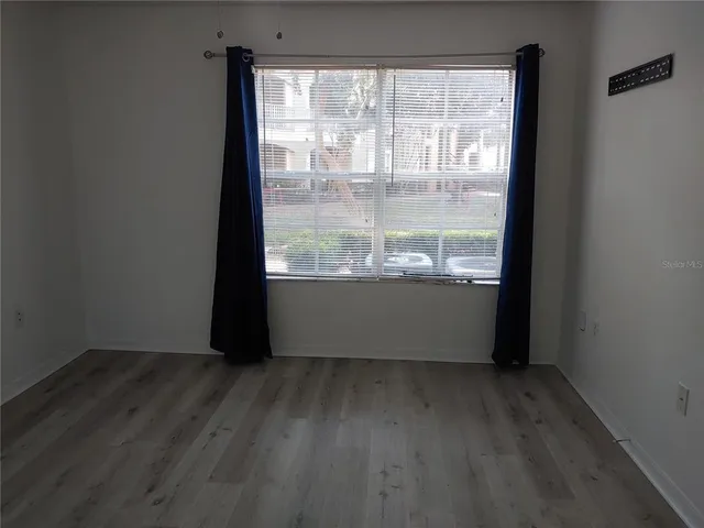 a view of a room with wooden floor and doors