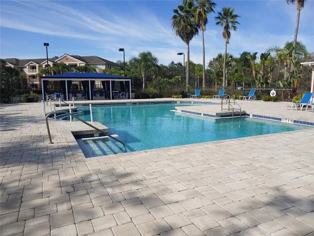a view of a swimming pool with a patio and a garden