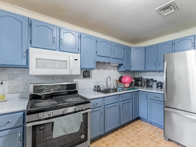 a kitchen with stainless steel appliances granite countertop a stove a refrigerator and a sink