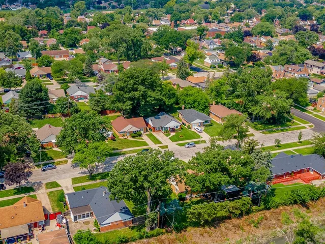 an aerial view of residential houses with outdoor space and trees all around