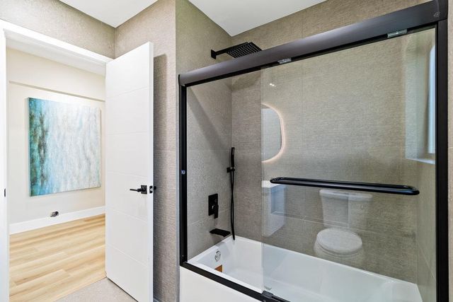 a white house with a small yard and wooden fence