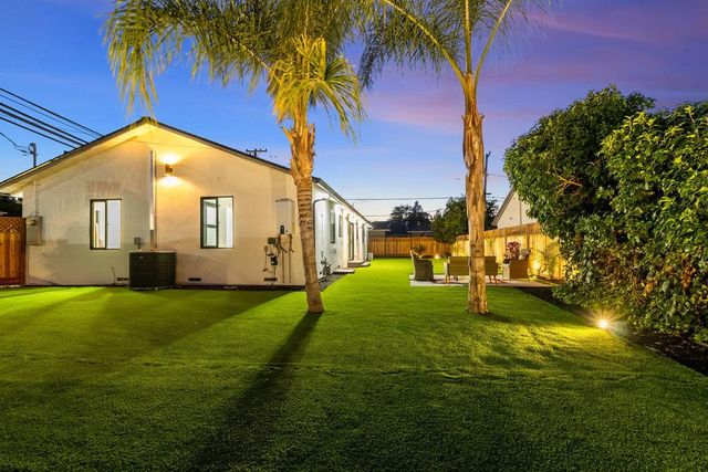 a living room with furniture kitchen view and a large window