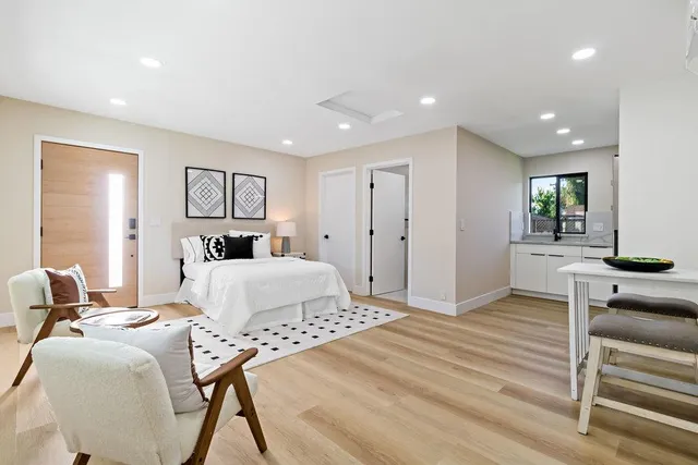 a view of a kitchen with a sink wooden cabinets and entryway