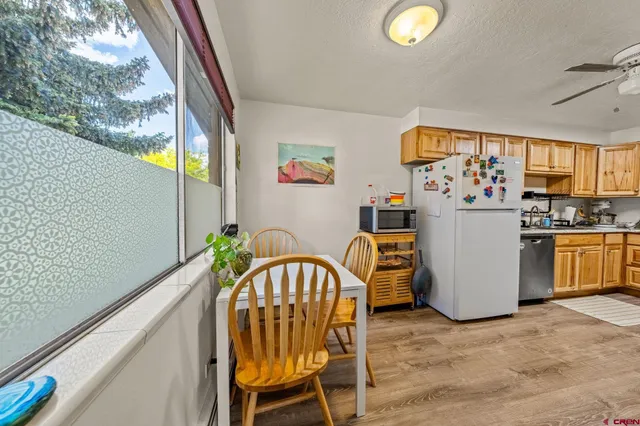 a view of a kitchen with furniture and refrigerator