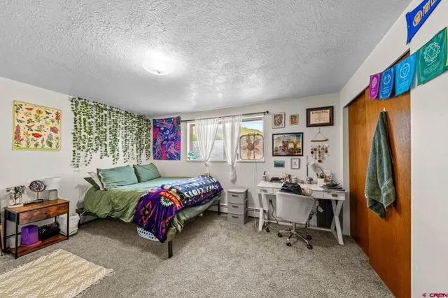 a bedroom with furniture and a large window