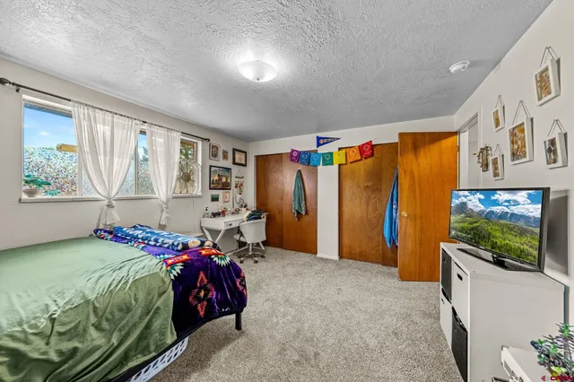 a bedroom with a bed and a flat screen tv