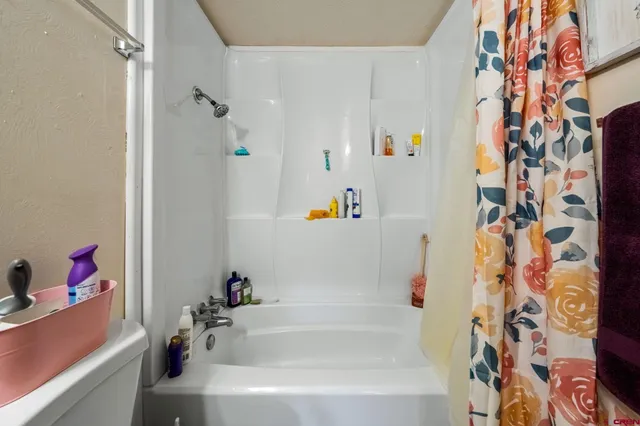 a bathroom with a bathtub and a shower curtain