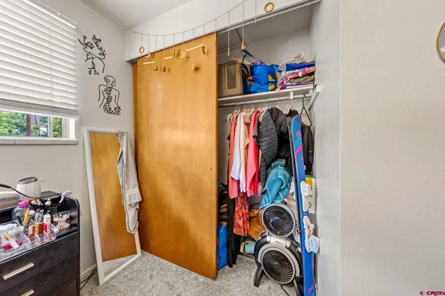 a view of walk in closet with clothes and shoes