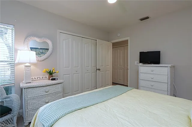 a bedroom with a bed and a flat tv screen on dresser