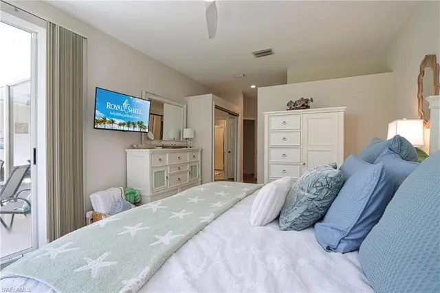 a bedroom with a bed and a flat tv screen on dresser