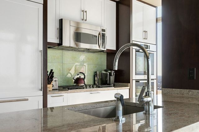 a kitchen with stainless steel appliances granite countertop a sink and a microwave