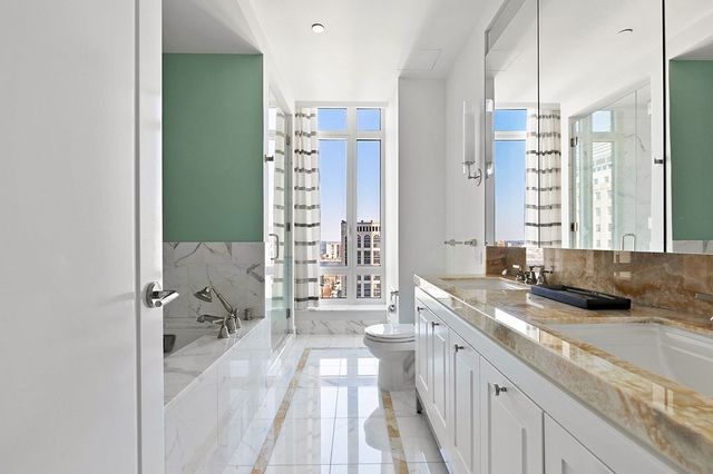 a spacious bathroom with a granite countertop sink and a large mirror