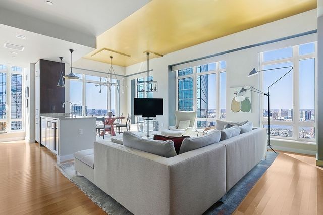 a living room with furniture large window and wooden floor