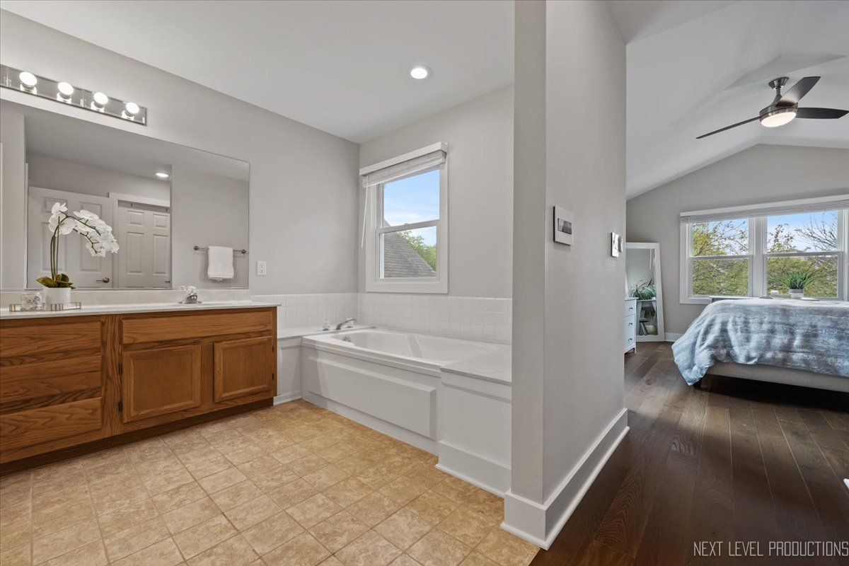 1257 Rhodes Lane Naperville, IL 60540 - Photo 16 of 24 a en suite bathroom with a sink a tub and a large mirror
