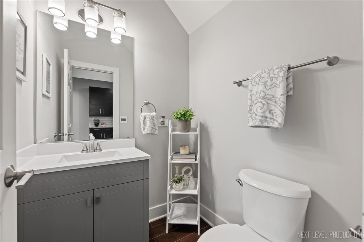 1257 Rhodes Lane Naperville, IL 60540 - Photo 10 of 24 a bathroom with a toilet a sink and mirror