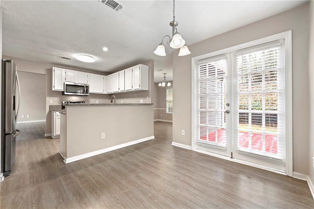 2065 Arbor Forest Drive Southwest Marietta, GA 30064 - Photo 6 of 15 a kitchen with stainless steel appliances granite countertop a refrigerator a sink dishwasher a stove and white cabinets with wooden floor