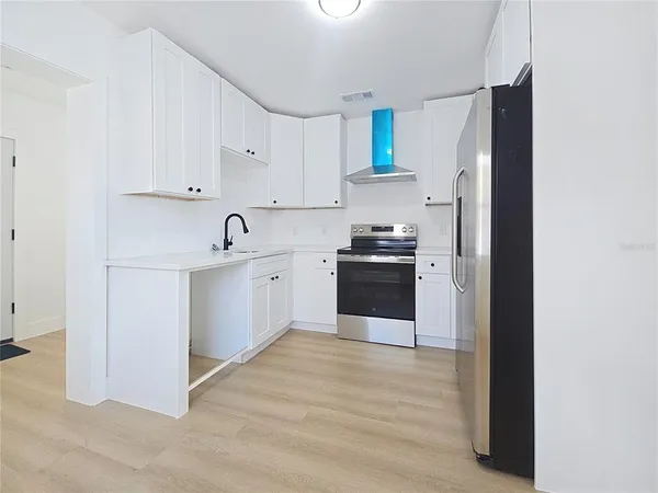a kitchen with stainless steel appliances granite countertop a refrigerator sink and cabinets