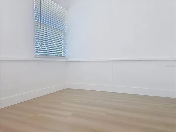 a view of a small space with wooden floor and a window