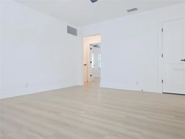 a view of an empty room with wooden floor