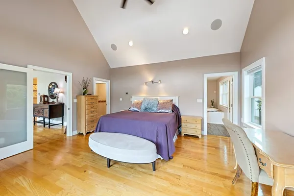 a spacious bedroom with a bed and wooden floor