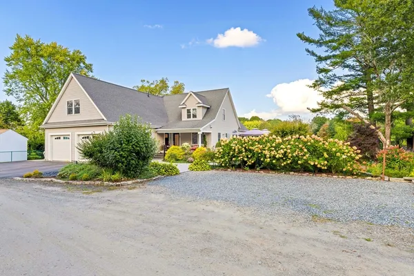 a view of a house with a yard and potted plants