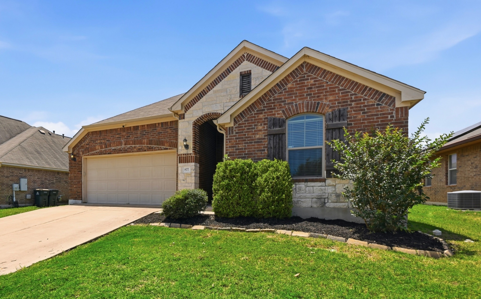 877 Hot Spring Valley Buda, TX 78610 - Photo 2 of 36 a front view of a house with a yard and garage