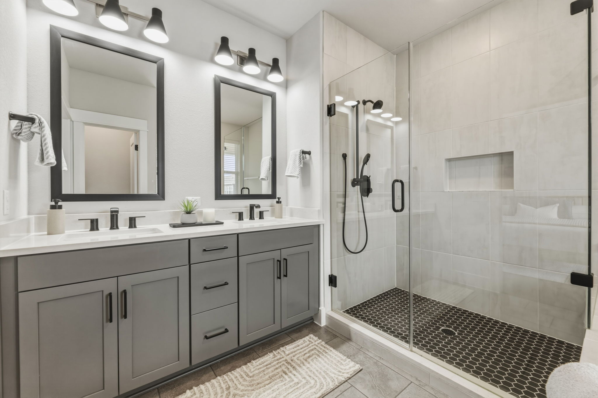 2929 Moreno Street Austin, TX 78723 - Photo 34 of 40 Double vanity with quartz countertops, gray shaker cabinetry, and matte black fixtures