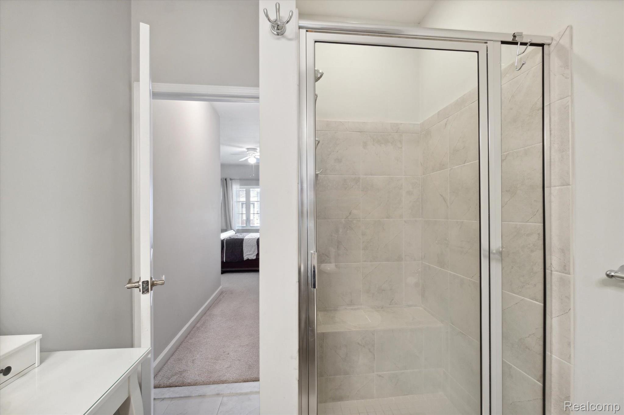 5662 Arbor Chase Drive Ann Arbor, MI 48103 - Photo 22 of 27 Glass-enclosed shower with tiled walls and a built-in bench