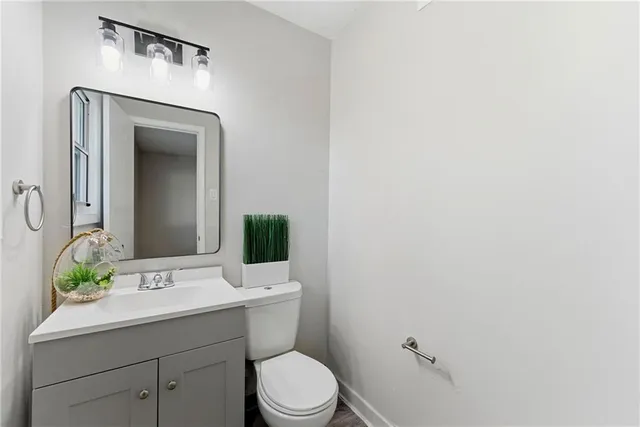 a bathroom with a toilet a sink and mirror
