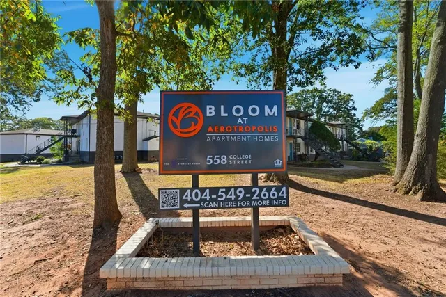 a view of a sign board with large tree
