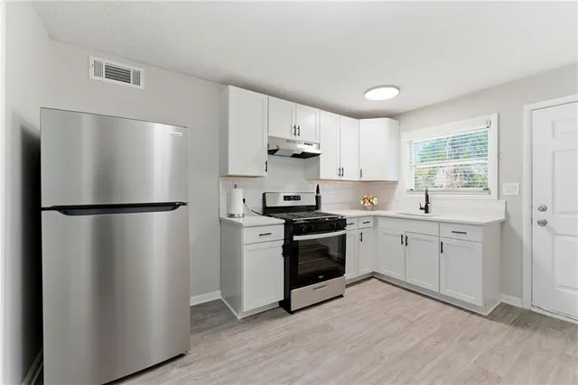 a kitchen with a refrigerator stove and sink