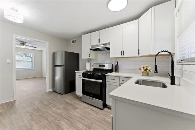 a kitchen with a refrigerator sink and cabinets