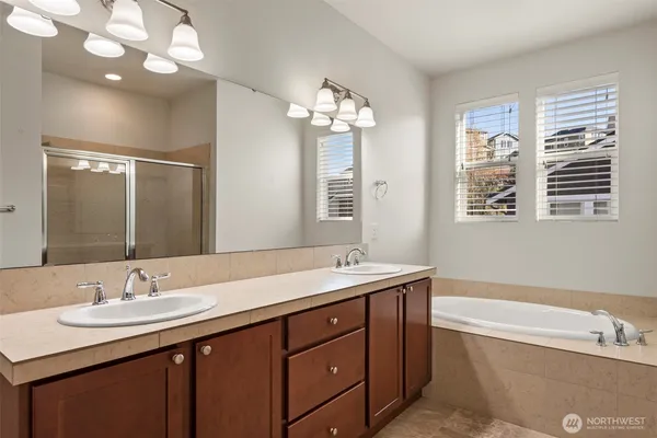 a bathroom with a sink double vanity granite and a bathtub