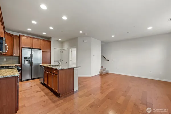 a kitchen with stainless steel appliances granite countertop a refrigerator and a stove top oven