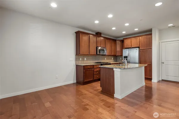 a kitchen with a refrigerator and a stove top oven
