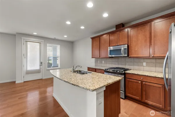 a kitchen with stainless steel appliances granite countertop refrigerator sink and cabinets
