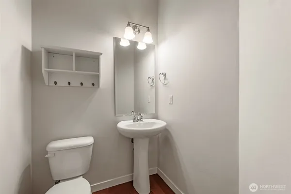 a bathroom with a toilet a sink and mirror