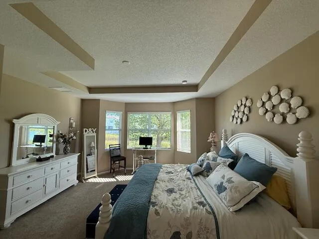 a bedroom with a bed and a flat tv screen on dresser