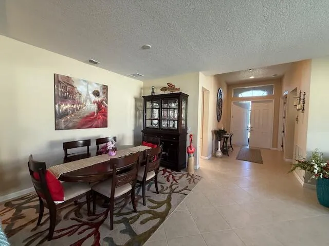 a kitchen with kitchen island granite countertop a table chairs sink and cabinets