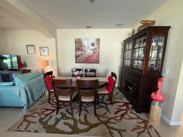 a kitchen with granite countertop stainless steel appliances a refrigerator a stove a sink a dining table and chairs