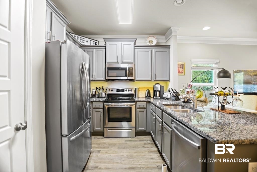 25806 Pollard Road, Unit 27 Daphne, AL 36526 - Photo 18 of 46 Kitchen with stainless steel appliances, dark stone counters, a peninsula, gray cabinets, and ornamental molding
