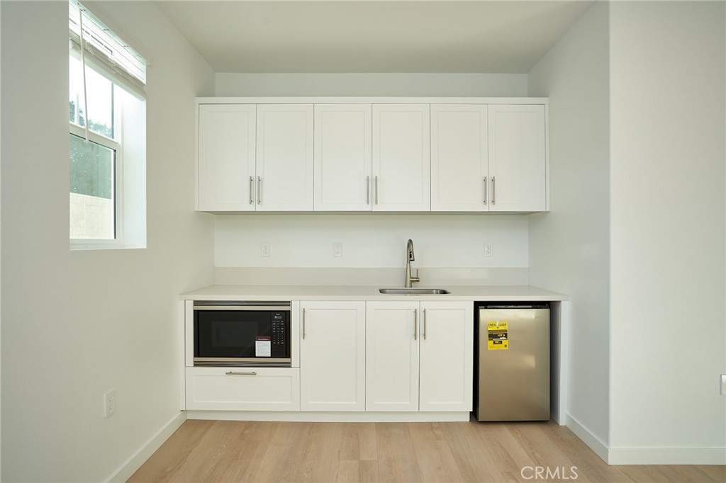 2448 Haley Pt Drive, Unit 105 Ventura, CA 93003 - Photo 8 of 27 a view of kitchen with granite countertop white cabinets and sink