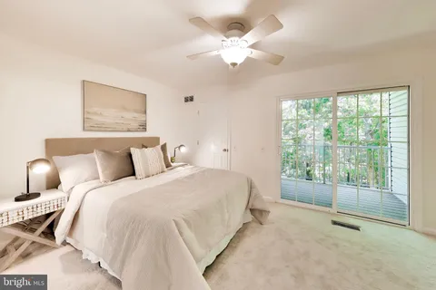 a spacious bedroom with a large bed and a chandelier