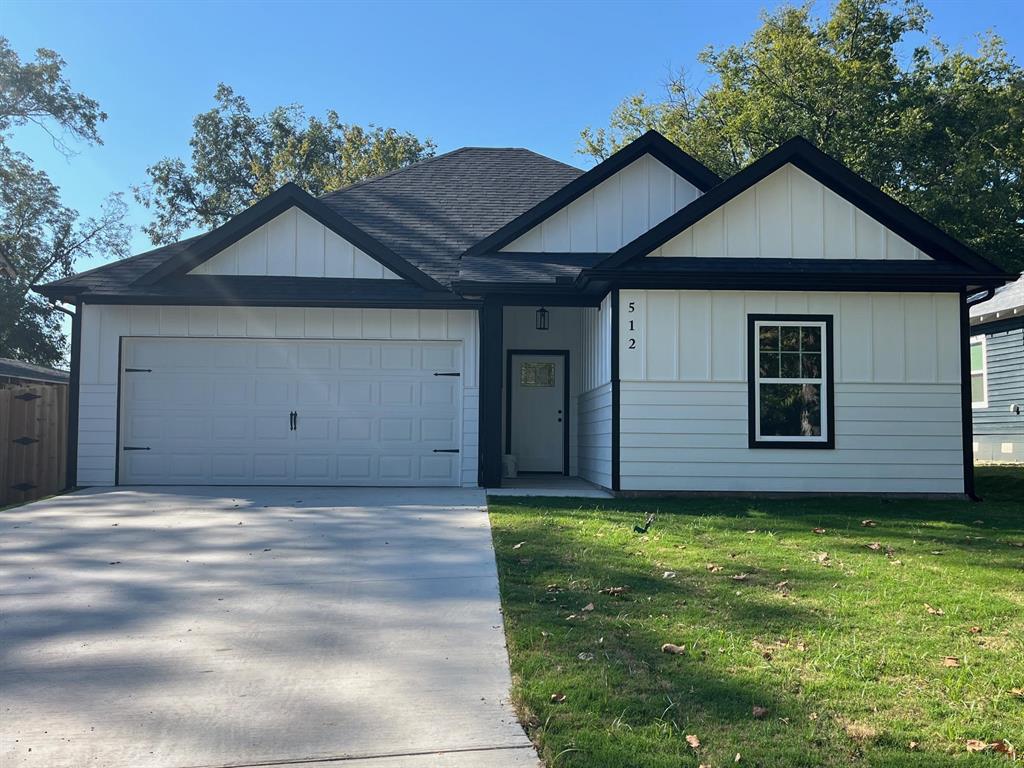 View of front of home featuring a front lawn, roof with shingles, driveway, a garage, and board and batten siding