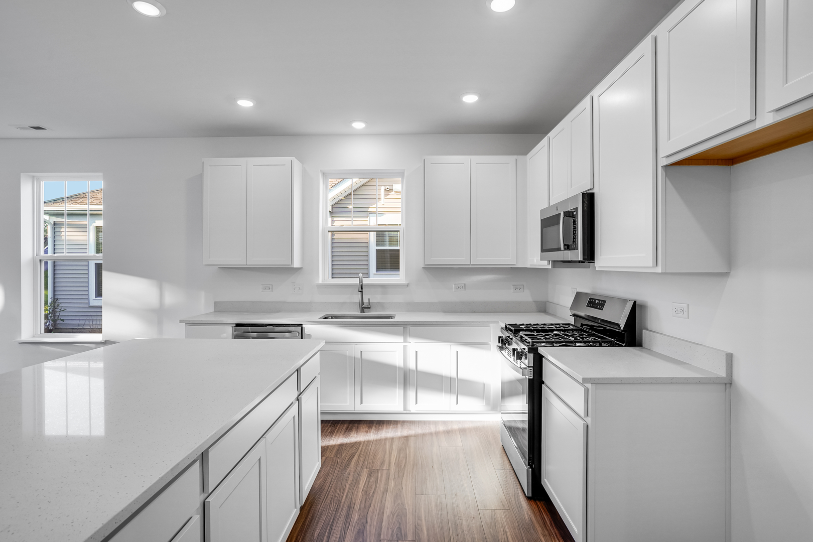 12231 Barcroft Circle Huntley, IL 60142 - Photo 2 of 38 a kitchen with a sink a stove a microwave and cabinets
