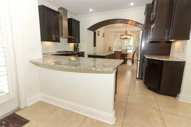 a view of an empty room with wooden floor and a ceiling fan