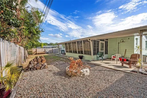 a view of a backyard with large trees and couches